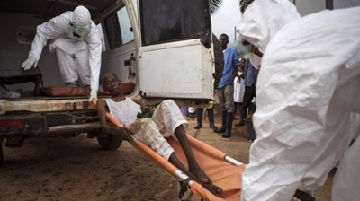 Healthcare workers load a man suspected of suffering from the Ebola virus onto an ambulance in Kenema, Sierra Leone. (Photo: AP)