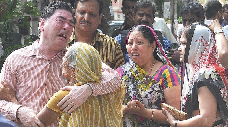 Relatives grieve over the murder of Santhoshi Bai and her daughter-in-law Latha Dinesh at Vasanth Nagar in Bengaluru on Monday 	(Photo: DC)