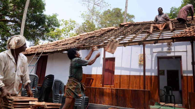 Repair work of a roof of a house damaged during the Puttingal Temple Fireworks undertaken in Paravoor. (Photo: PTI)