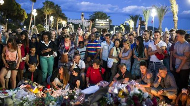 People gather at a makeshift memorial to honor the victims of an attack, near the area where a truck mowed through revelers in Nice. (Photo: AP)