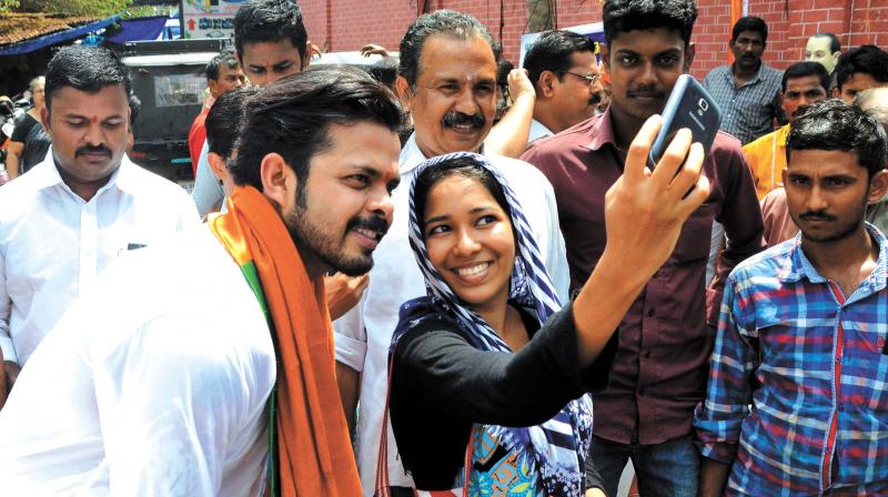 BJP Thiruvananthapuram candidate and cricketer Sreesanth joins for a selfie during an election campaign at Palayam market on Thursday.