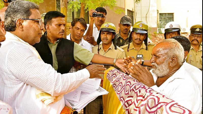 Chief Minister Siddaramaiah receives a petition from a farmer in drought-hit Bilagi taluk in Bagalkot district on Monday DC Chief Minister Siddaramaiah receives a petition from a farmer in drought-hit Bilagi taluk in Bagalkot district on Monday DC
