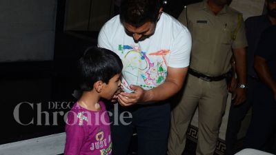 Aamir Khan feeds a boy a piece of his birthday cake.