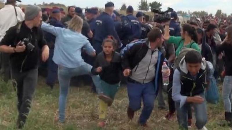 A Hungarian camerawoman,in blue, kicks out at a young migrant who had just crossed the border from Serbia near Roszke Hungary. (Photo: AP) A Hungarian camerawoman,in blue, kicks out at a young migrant who had just crossed the border from Serbia near Roszke Hungary. (Photo: AP)