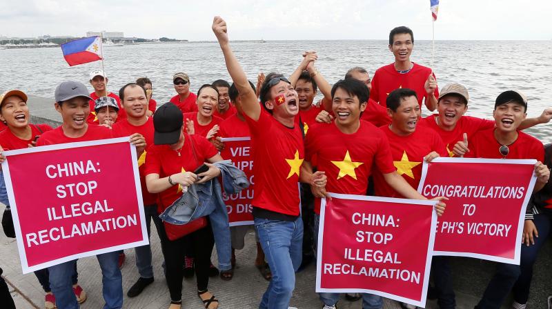Vietnamese expatriates cheer while displaying placards during a rally by the Manila's baywalk before the Hague-based U.N. international arbitration tribunal is to announce its ruling on South China Sea. (Photo: AP) Vietnamese expatriates cheer while displaying placards during a rally by the Manila's baywalk before the Hague-based U.N. international arbitration tribunal is to announce its ruling on South China Sea. (Photo: AP)