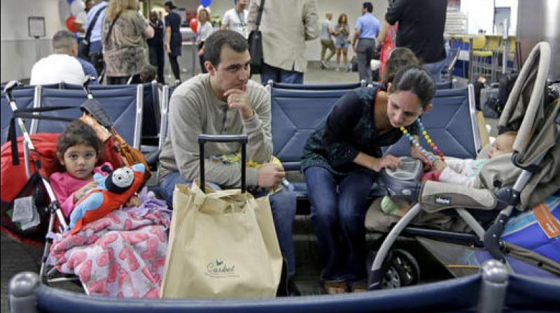 Mario Martinez, second from left, and his wife Nimaris Niebla, sit with their children Daniela, left, and Olivia, right, as they wait to depart to Santa Clara, Cuba, to visit their family there. (Photo: AP) Mario Martinez, second from left, and his wife Nimaris Niebla, sit with their children Daniela, left, and Olivia, right, as they wait to depart to Santa Clara, Cuba, to visit their family there. (Photo: AP)