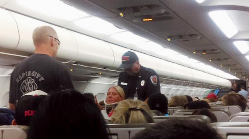 This photo provided by Rhonda Lynam shows a crew member in a neck brace being removed from a JetBlue aircraft after it landed at the airport in Rapid City. (Photo: AP) This photo provided by Rhonda Lynam shows a crew member in a neck brace being removed from a JetBlue aircraft after it landed at the airport in Rapid City. (Photo: AP)