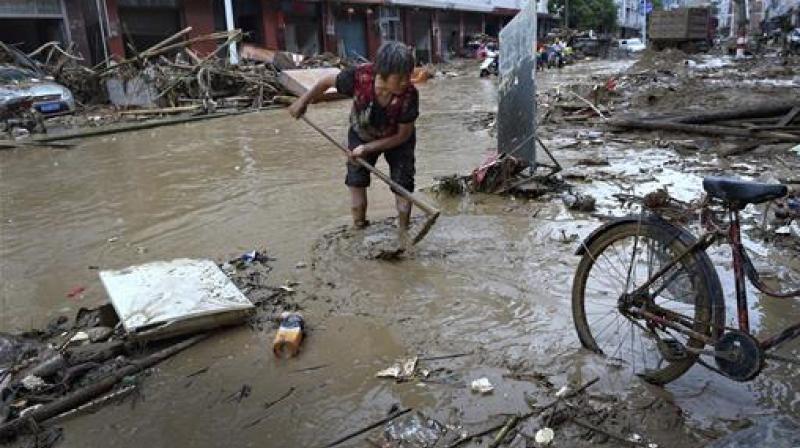 A woman clears mud and debris on a street following Typhoon Nepartak hit in Minqing county in southeast China's Fujian province. (Photo: AP) A woman clears mud and debris on a street following Typhoon Nepartak hit in Minqing county in southeast China's Fujian province. (Photo: AP)