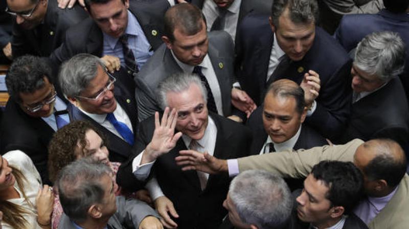 Brazil's President Michel Temer, center, is surrounded by senators as he arrives to take the presidential oath at the National Congress, in Brasilia, Brazil. (Photo: AP) Brazil's President Michel Temer, center, is surrounded by senators as he arrives to take the presidential oath at the National Congress, in Brasilia, Brazil. (Photo: AP)