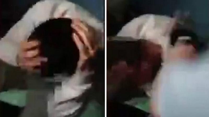 As he tries to bury his face with his hands, one of the inmates pulls him up and hits on his head. (Photo: YouTube Screengrab) As he tries to bury his face with his hands, one of the inmates pulls him up and hits on his head. (Photo: YouTube Screengrab)
