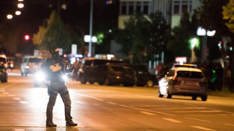 A masked policeman stands on the street in front of the Olympia mall where a shooting took place in Munich, southern Germany. (Photo: AP) A masked policeman stands on the street in front of the Olympia mall where a shooting took place in Munich, southern Germany. (Photo: AP)